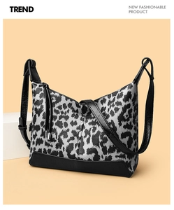 Dettaglio ravvicinato della borsa a spalla leopardata con rifiniture nere e nappe