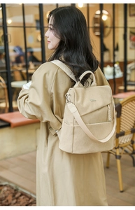 Detail of beige corduroy multi-functional backpack with side pockets and charm