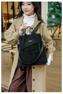 Detail of black corduroy backpack showing textured fabric and stylish zipper pocket
