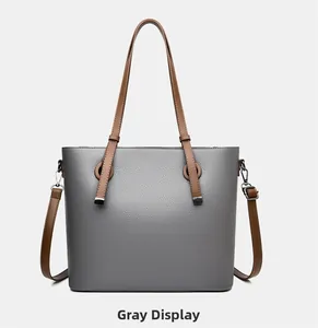 Détail du sac cabas gris avec poignées marron et texture cuir à grain litchi