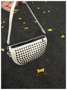 Detailed close-up of white Hobo bag featuring black rivets and silver metal hardware