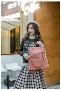 Outdoor lifestyle shot of pink corduroy multi-way backpack with wide canvas straps
