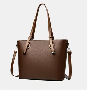 Vue latérale du sac fourre-tout marron foncé avec texture grainée et anneaux en métal