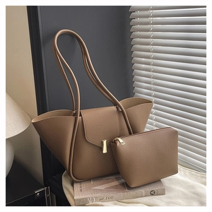 Detail of dark brown pebble leather shoulder bag with gold clasp and matching mini pouch