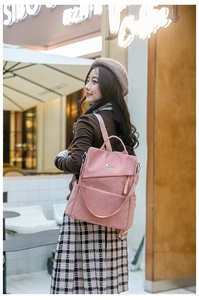 Detail of pink corduroy backpack featuring metal accents and woven zipper pulls