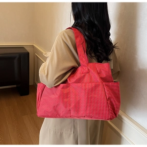 Detailed close-up of red and white gingham canvas tote bag with wide shoulder strap