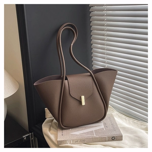 Detail of brown litchi pattern leather tote with golden bar lock and wing-shaped silhouette