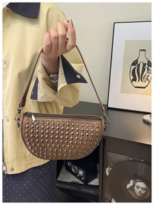 Detail of brown vintage shell bag with metallic silver studs and leather strap