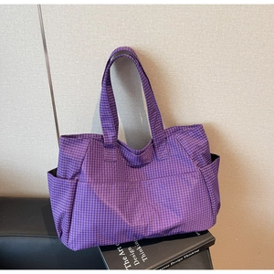 Detail view of purple checkered tote bag featuring side pockets and spacious front compartment