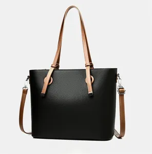 Détail du grand sac cabas en cuir grainé noir avec des anses contrastées marron clair