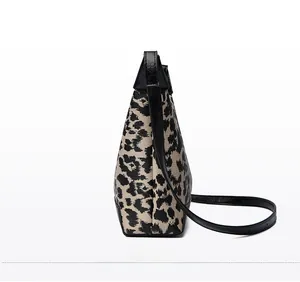 Dettaglio laterale della borsa leopardata in tela con finiture in pelle nera