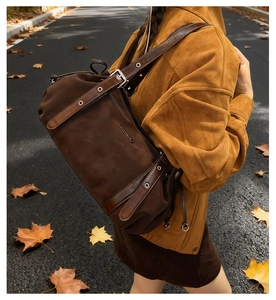 Detail of dark brown leather tote with metal grommet strap and drawstring closure