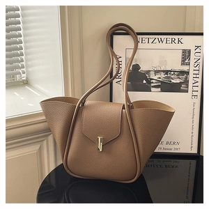Close-up of khaki brown pebble leather tote with gold hardware and winged design