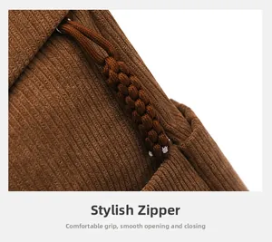 Detail of brown corduroy fabric and woven zipper pull on minimalist travel backpack