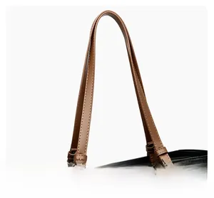 Gros plan du sac cabas en cuir bicolore avec anses brunes et texture grainée noire