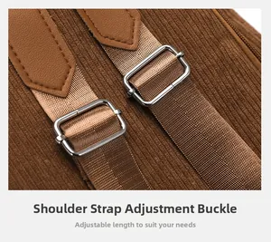 Detailed macro view of adjustable metal buckle and leather trim on brown corduroy backpack