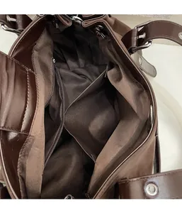Detail view of the brown leather Boston bag interior with zipper pocket and silver rivets