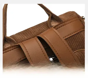 Detail of reinforced stitching on brown corduroy backpack handle and strap connection