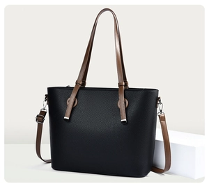 Détail du sac cabas en cuir grainé noir avec anses brunes et finitions argentées