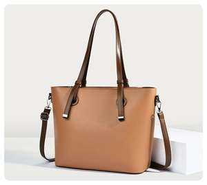 Détail d'un sac cabas marron avec cuir grainé et finitions en métal argenté brillant