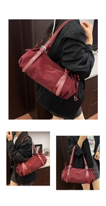 Detail view of burgundy cylindrical shoulder bag with metal eyelets and silver logo plaque