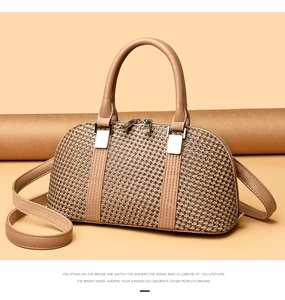 Detail of light brown woven texture handbag with smooth leather straps and silver zippers