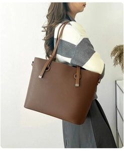 Vue détaillée du grand sac cabas marron foncé en cuir grainé porté par un mannequin