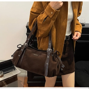 Detail view of dark coffee nylon shoulder bag with silver eyelets and leather straps