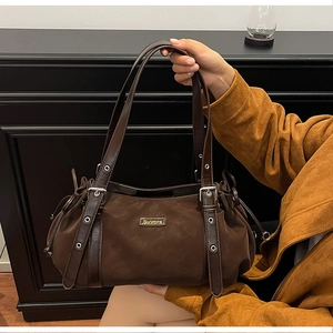 Detail of vintage brown leather tote bag with Suvora metal logo and side drawstring