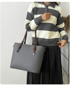Détail d'un grand sac cabas gris texture litchi porté par un mannequin en tenue décontractée