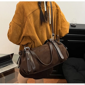 Detail view of large dark brown leather tote bag with Suvora logo and side drawstrings