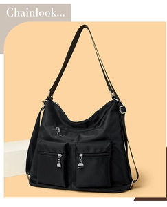 Detailed macro of black nylon multi-pocket bag with silver zippers on warm background