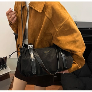 Detail of black multi-functional tote bag with silver Suvora nameplate and leather straps