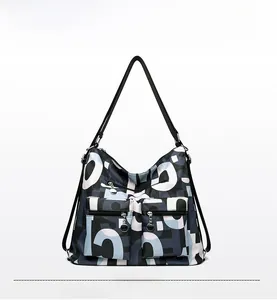 Detailed shot of large nylon tote bag with abstract letter prints and dual zipper pockets