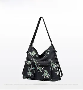 Detail of waterproof nylon backpack with teal bamboo leaf texture and functional zip pockets