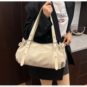 Close-up of beige faux leather tote with elegant pleated texture and SUVORA metal logo