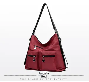 Detail of dark red nylon backpack with double front zipper pockets and silver metal pulls