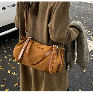Detail of caramel Boston bag with adjustable leather straps and side drawstring on wool coat