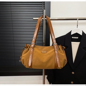 Detail of caramel pleated shoulder bag with silver buckles and Suvora logo branding