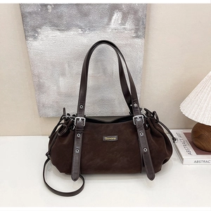 Detail of vintage brown suede tote bag with leather handles and drawstring closure
