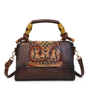 Vintage brown leather handbag with floral embossing and unique bamboo top handle