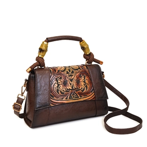 Vintage brown leather crossbody bag with floral embossing and bamboo handle details