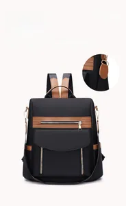 Detail der robusten Hakenbefestigung und braunen Kunstlederbesätze auf schwarzem Rucksack