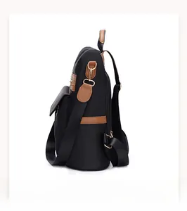 Seitenansicht des schwarzen Oxford-Rucksacks mit braunem Lederbesatz und Goldzippern