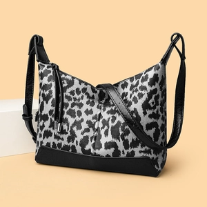 Borsa a tracolla leopardata con dettagli in pelle nera e nappa metallica decorativa