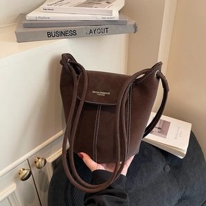 Deep brown matte leather bucket bag with white contrast stitching and rope shoulder straps