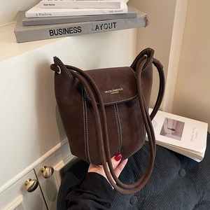 Dark brown suede bucket bag with contrast white stitching and round top handle