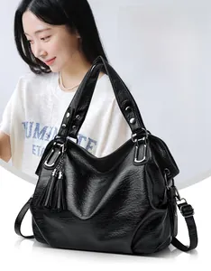 Detail of black pebbled leather tote bag with double tassels and silver hardware