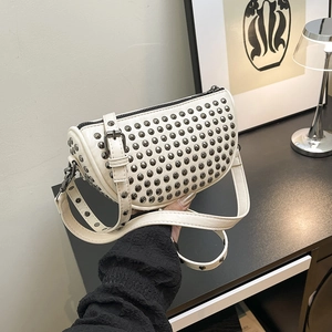 Chic cream leather half-moon crossbody bag with punk style gunmetal rivets and metal buckle