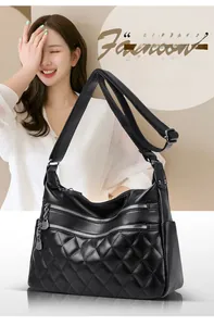 Close-up of black leather shoulder bag featuring quilted pattern and metal zippers